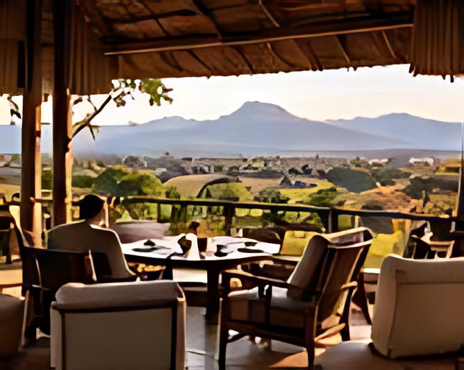 A lodge terrace laid with armchairs and a table, the plains opening out beyond